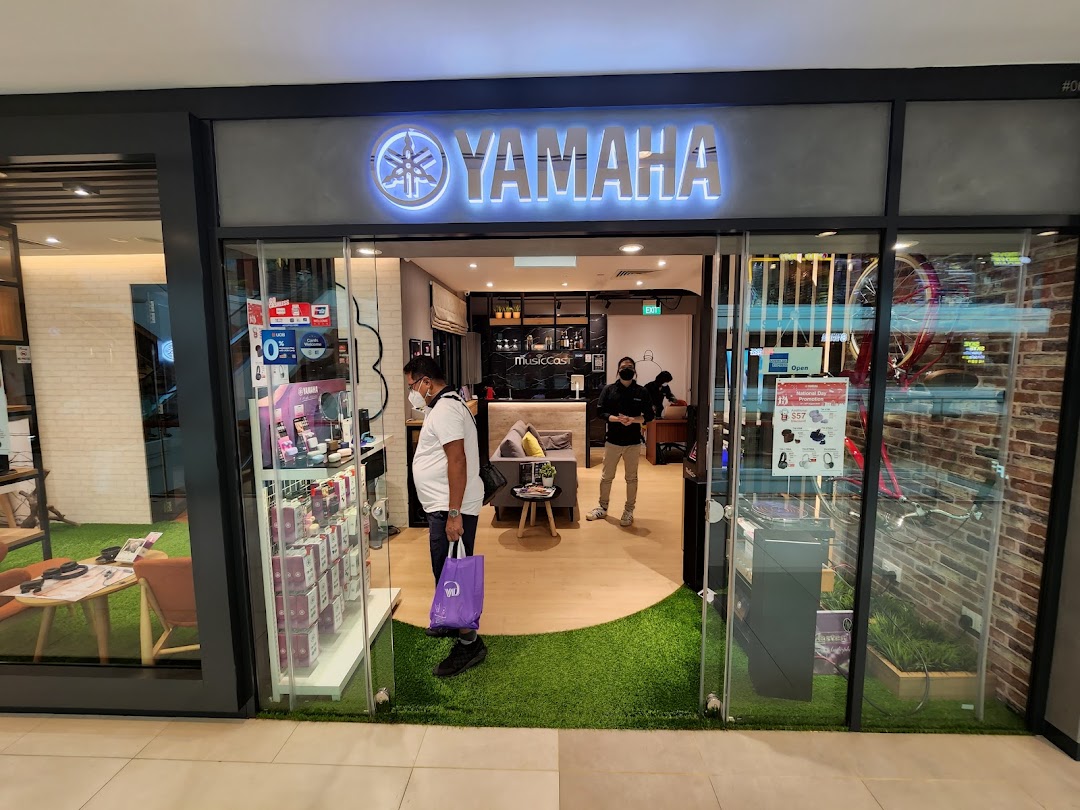 The inviting entrance of the Yamaha Music Store and Music School at Plaza Singapura, showcasing its bright logo.