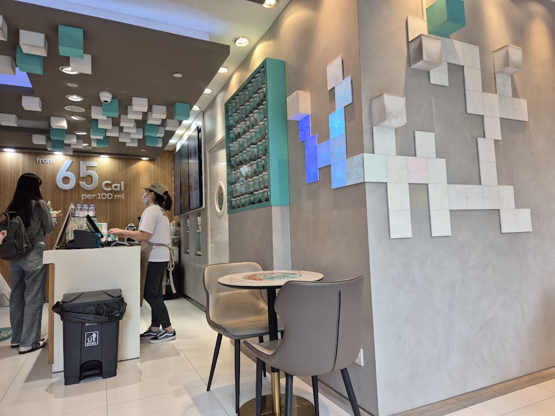 Interior view of Yolé Plaza Singapura, showing the counter, staff, a customer, and seating area.