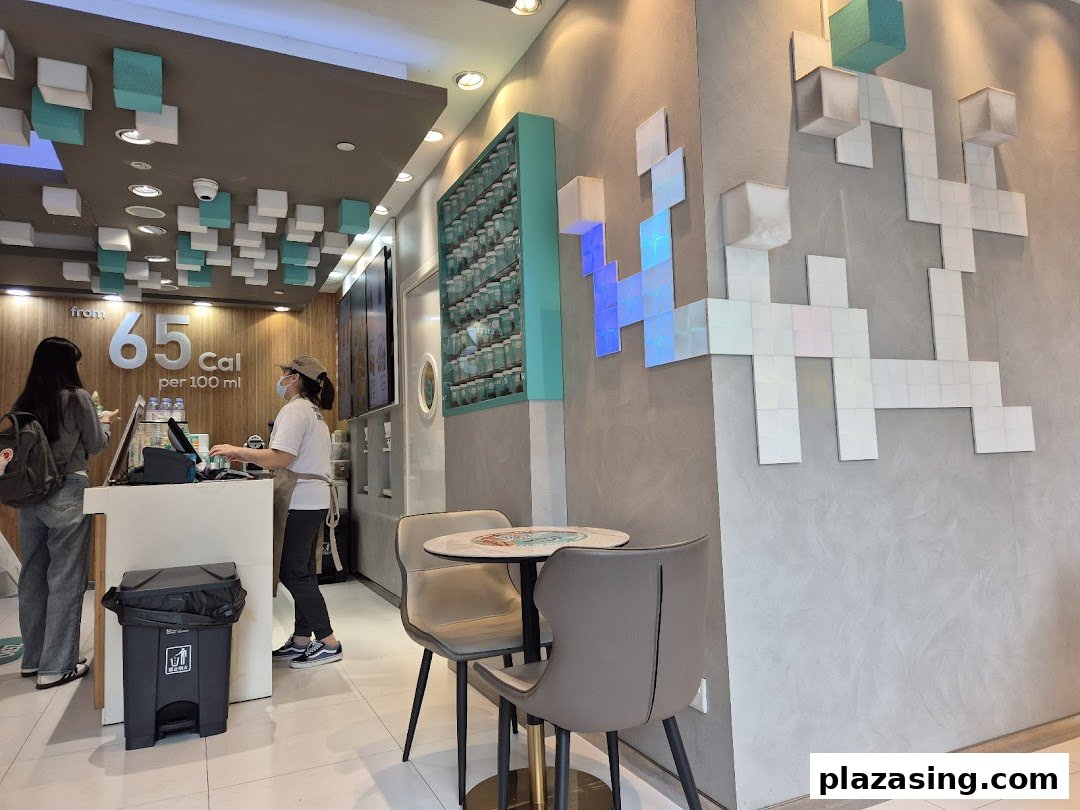 Interior view of Yolé Plaza Singapura, showing the counter, staff, a customer, and seating area.