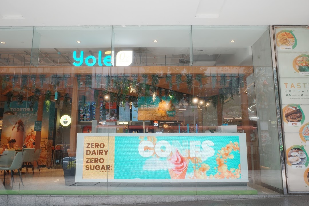 The storefront of Yolé Plaza Singapura, featuring its logo, interior view, and a digital display promoting cones.