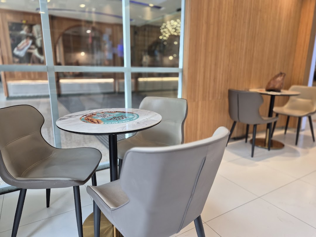 Comfortable seating area with modern tables and chairs at Yolé Plaza Singapura.