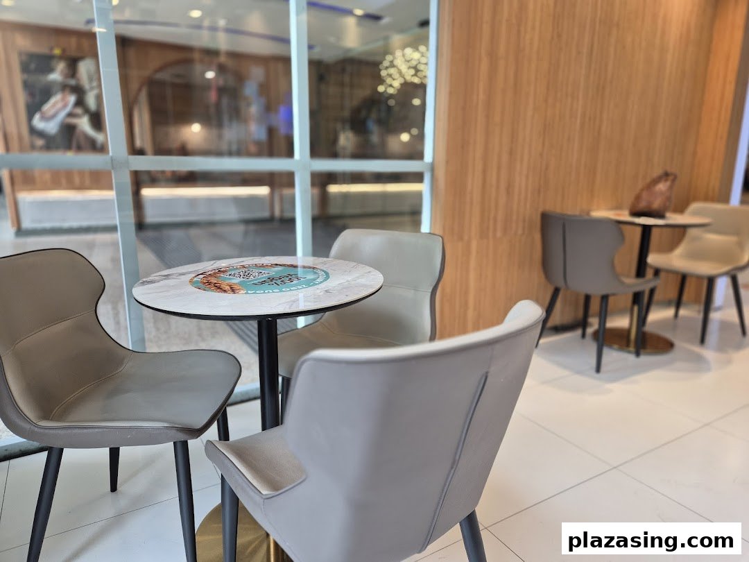 Comfortable seating area with modern tables and chairs at Yolé Plaza Singapura.