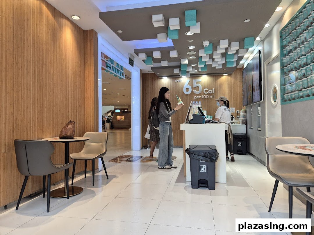 Interior view of Yolé Plaza Singapura, showing the counter, staff, customer, and seating area.