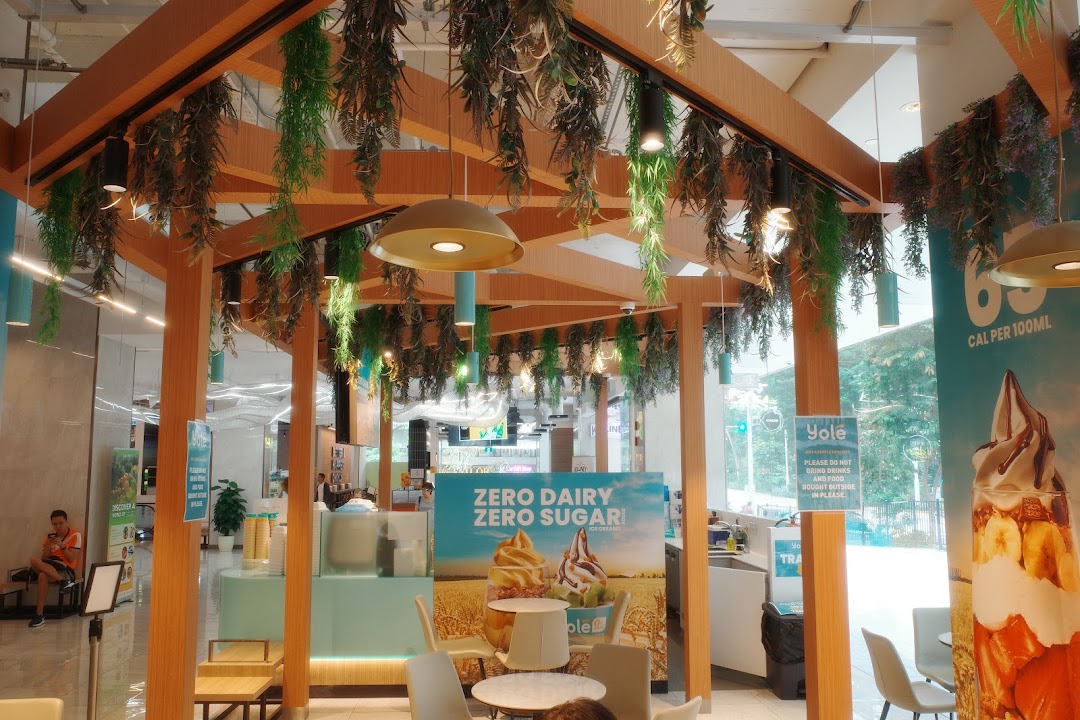 Interior view of Yolé Plaza Singapura, featuring the counter, seating area, and promotional banners.
