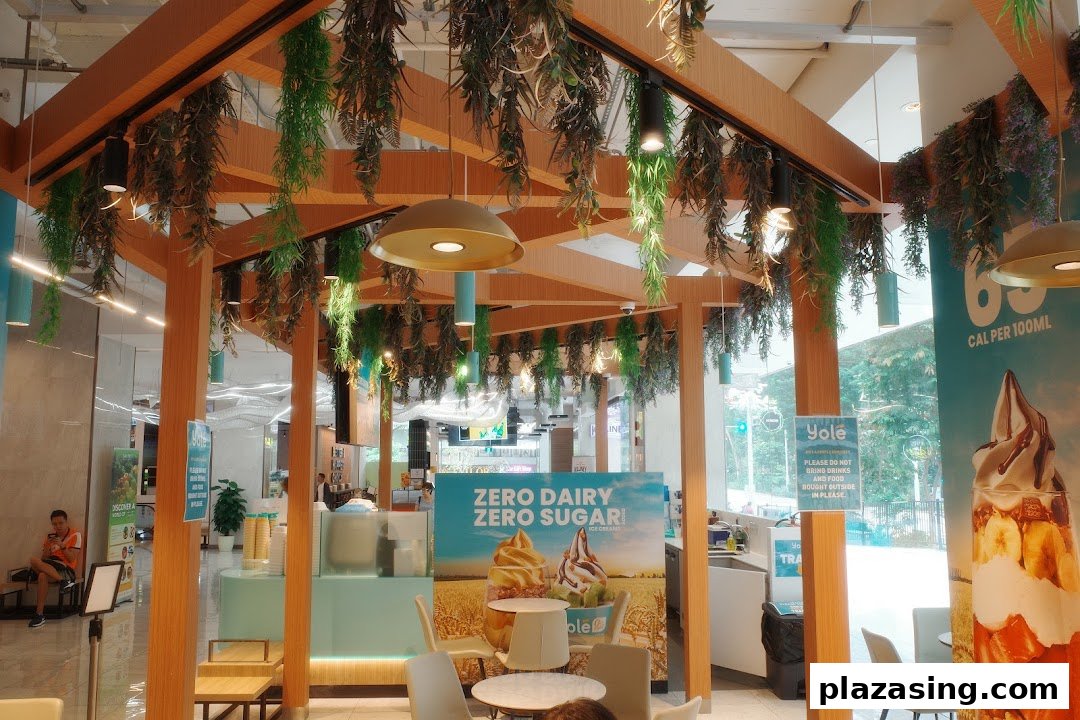 Interior view of Yolé Plaza Singapura, featuring the counter, seating area, and promotional banners.
