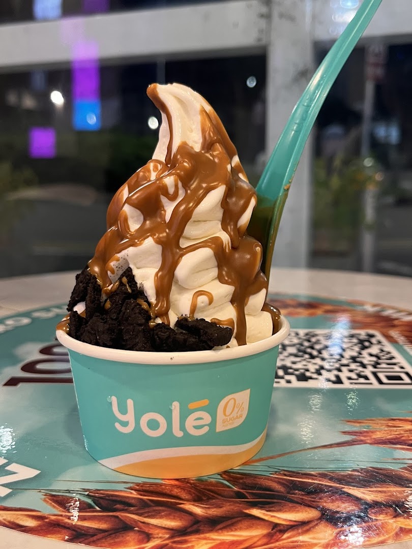 A delicious Yolé frozen yogurt cup with caramel drizzle and cookie crumbles.