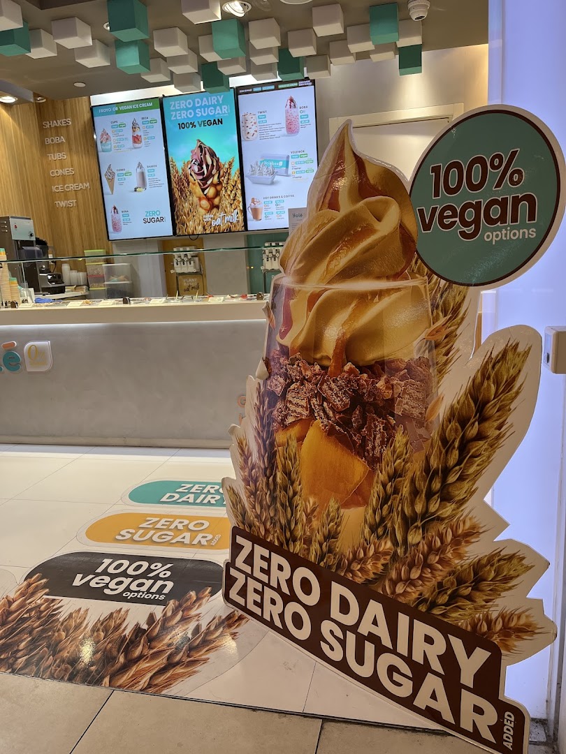 Interior view of Yolé, showcasing digital menu boards, counter, and promotional displays for vegan and sugar-free options.