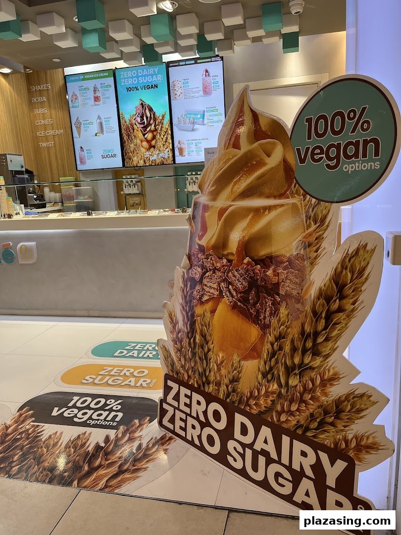 Interior view of Yolé, showcasing digital menu boards, counter, and promotional displays for vegan and sugar-free options.