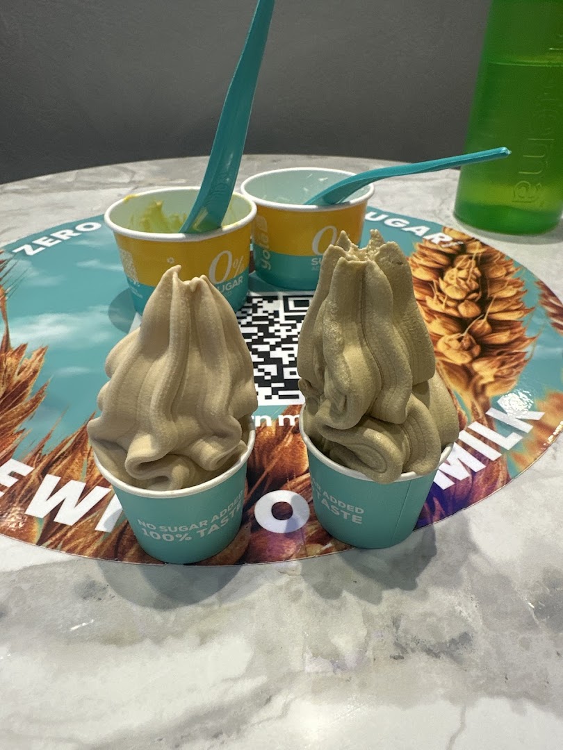 Two cups of Yolé frozen yogurt with spoons on a branded placemat.