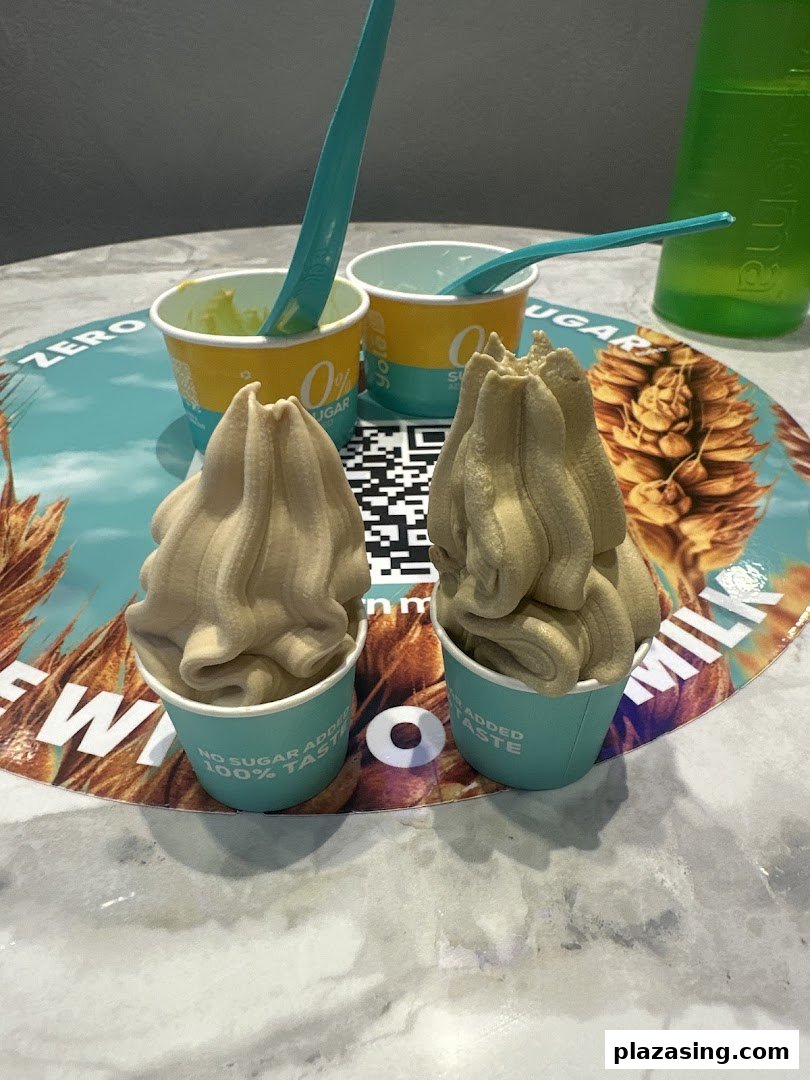Two cups of Yolé frozen yogurt with spoons on a branded placemat.