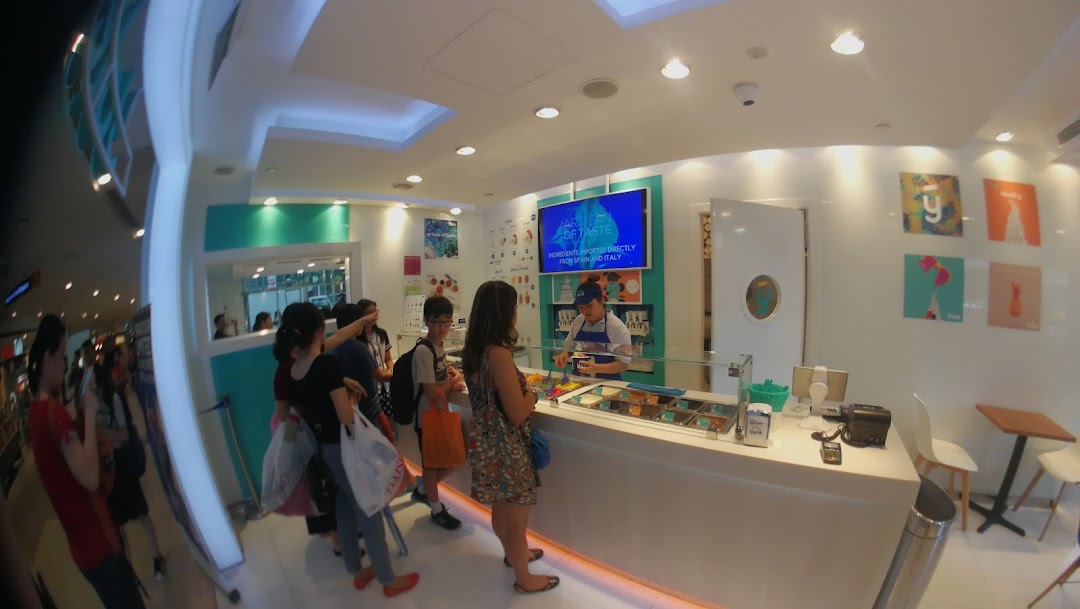 Customers queue at the counter of Yolé, a bright and modern frozen yogurt shop.