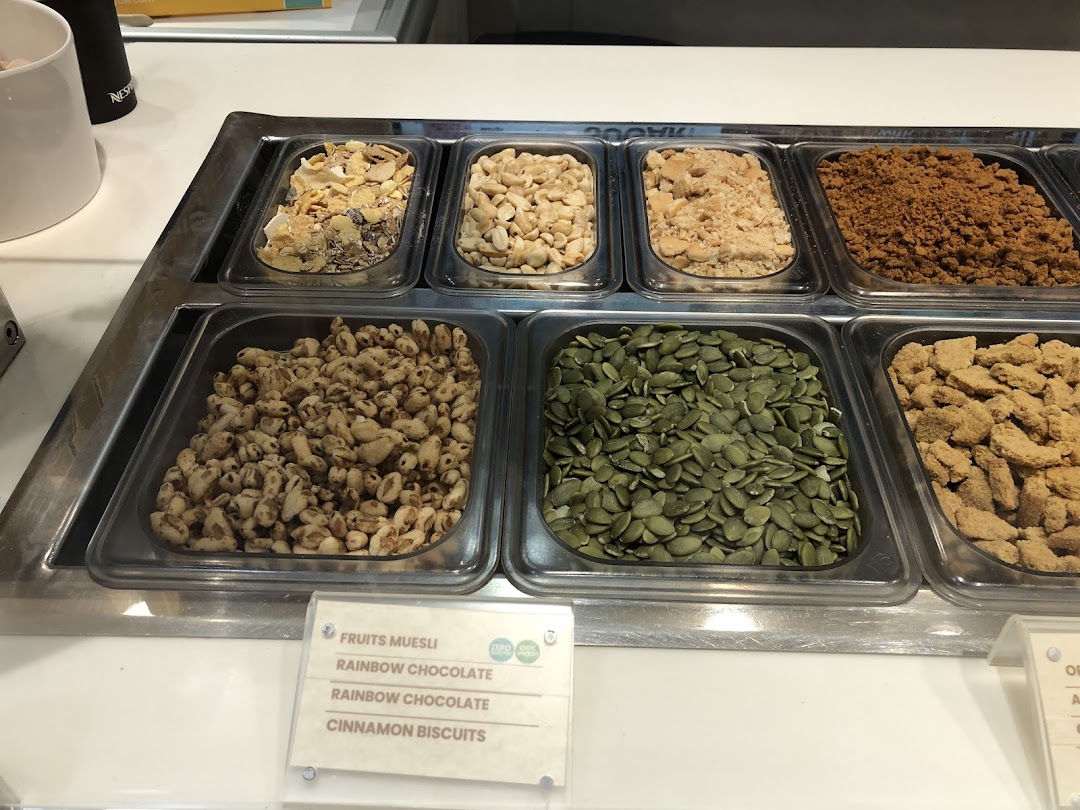 A vibrant display of various toppings including nuts, seeds, and cereals for desserts.