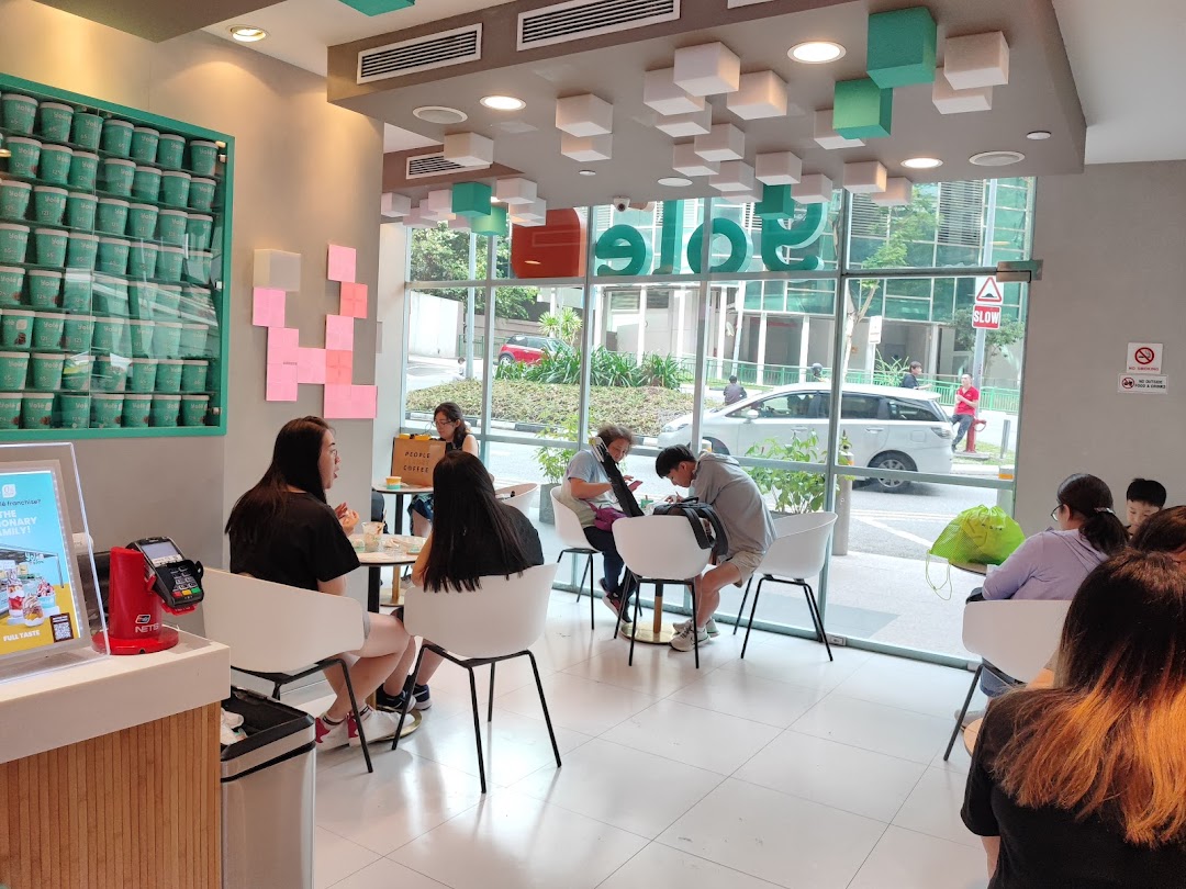 Interior view of Yolé Plaza Singapura, showing customers enjoying the bright, modern space with ample seating.
