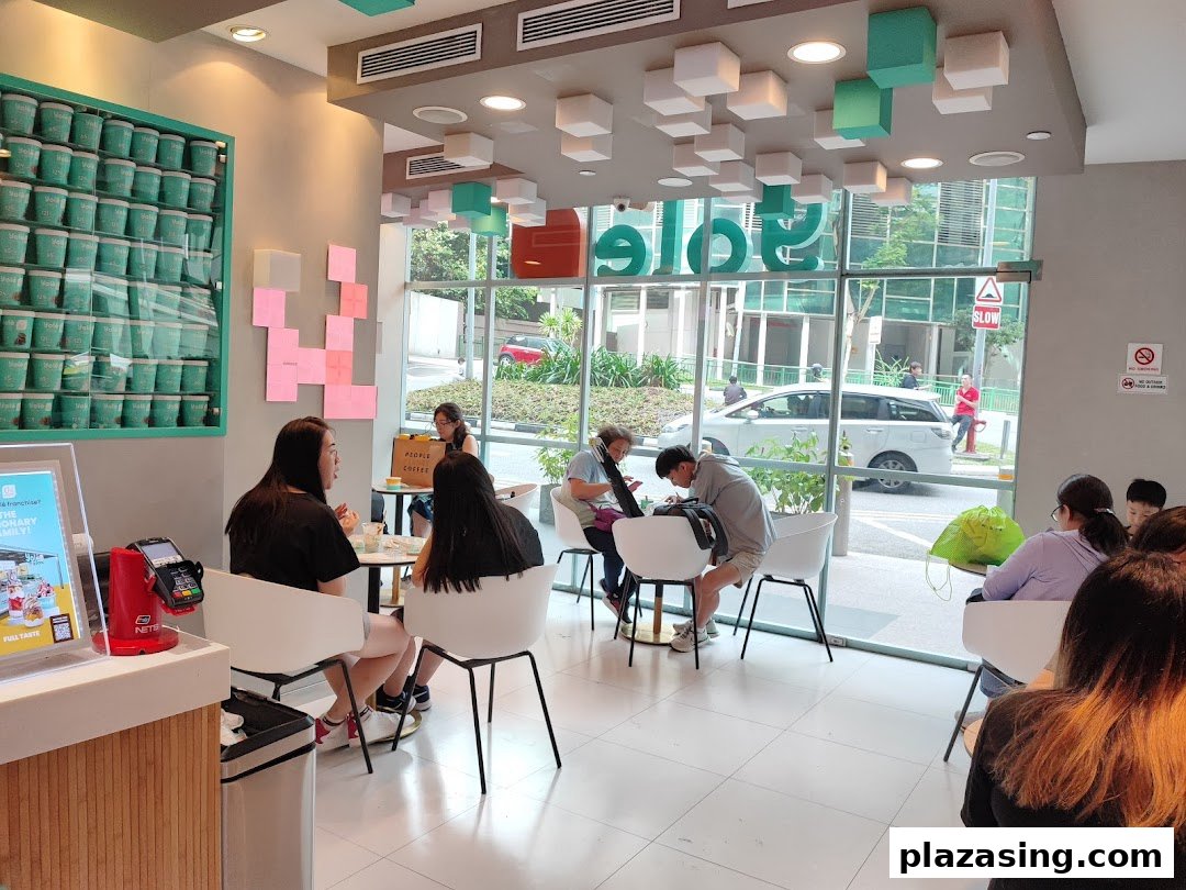 Interior view of Yolé Plaza Singapura, showing customers enjoying the bright, modern space with ample seating.