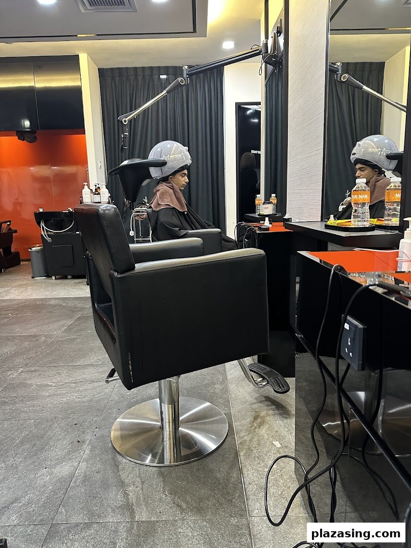 A customer receiving a hair treatment under a steamer at Yun Nam Hair Care.