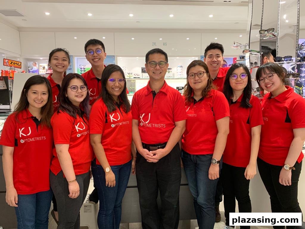 A team of friendly optometrists in red shirts smiling inside the ZEISS VISION CENTER by KJ Optometrists.