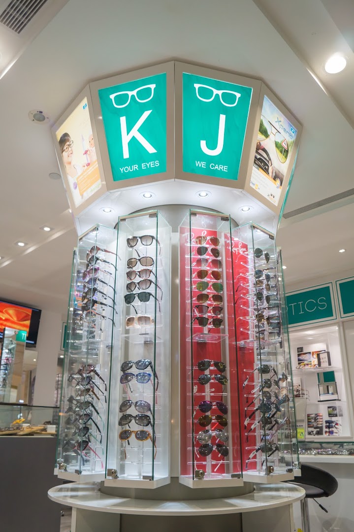 A central display stand showcasing numerous pairs of sunglasses and eyeglasses inside an optical shop.