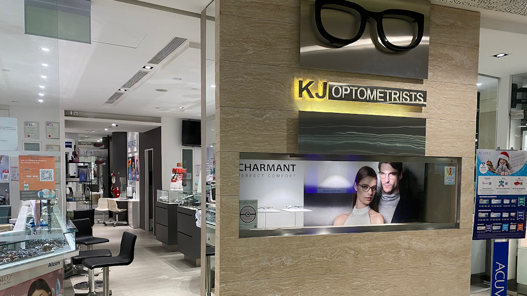 Interior view of KJ Optometrists, showcasing eyewear displays, seating, and professional branding.
