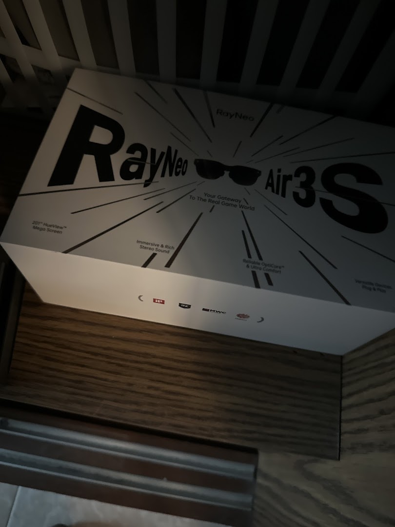 A RayNeo Air3S smart glasses product box displayed on a wooden shelf inside the optometrist shop.