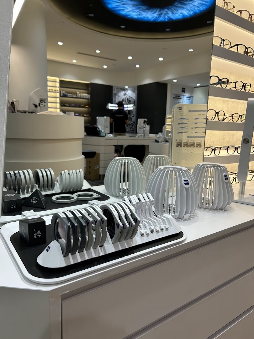 Interior view of ZEISS VISION CENTER, showcasing advanced optical display tools and stylish eyewear in a modern setting.
