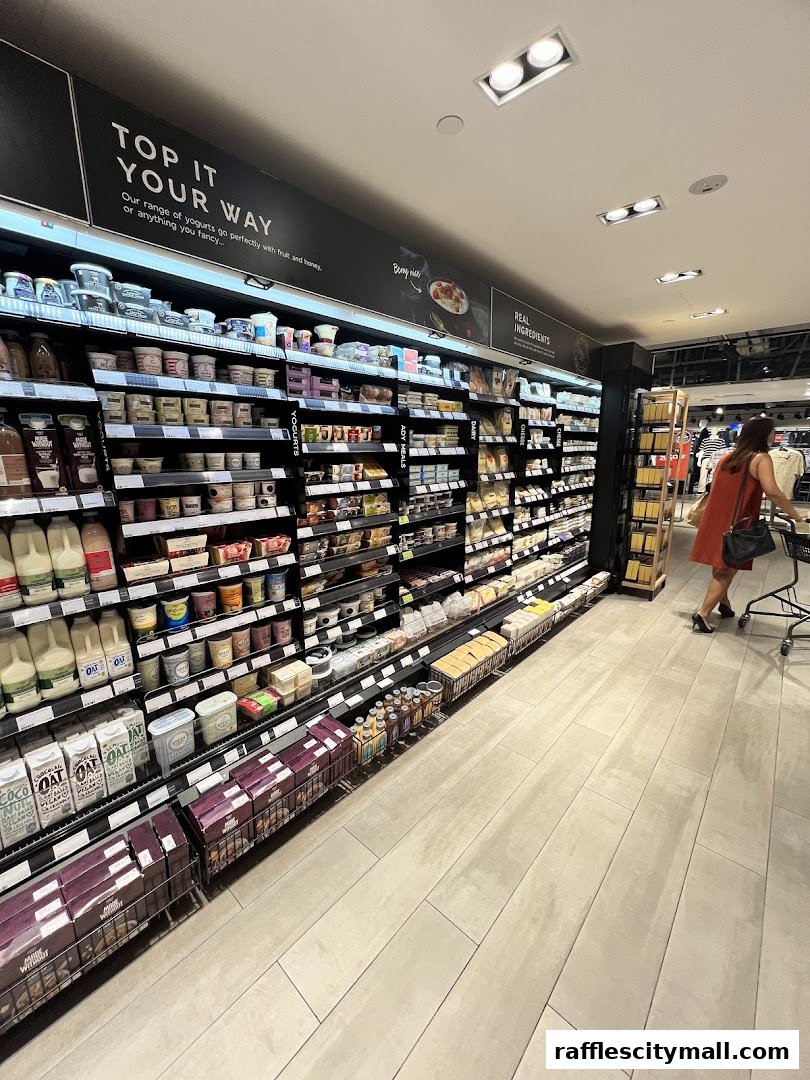 A wide aisle in a Marks & Spencer food section, showcasing yogurts and other dairy products.