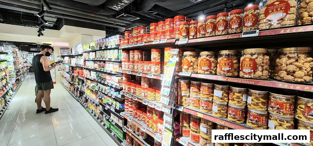 A shopper browses a well-stocked aisle of snacks and treats in a supermarket.