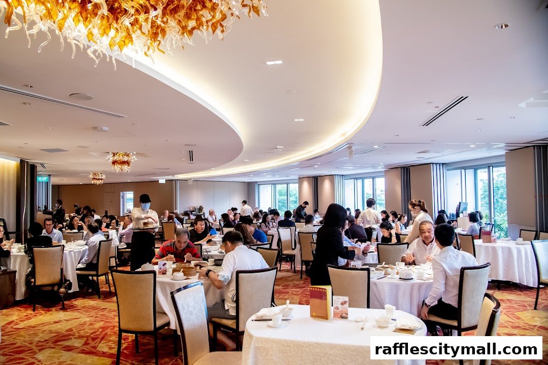 A busy Asian restaurant interior with many diners seated at round tables.