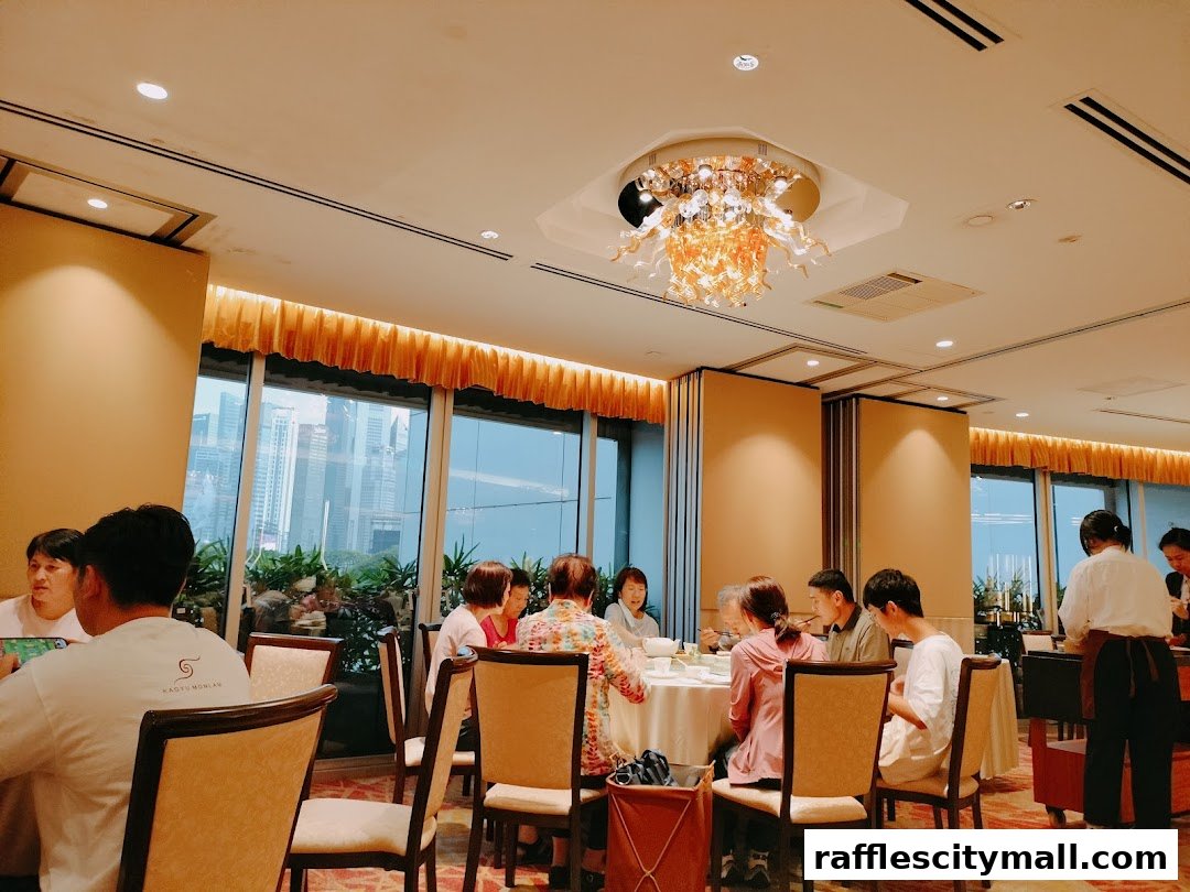 Diners enjoy a meal at Asia Grand Restaurant with a view of the city skyline.