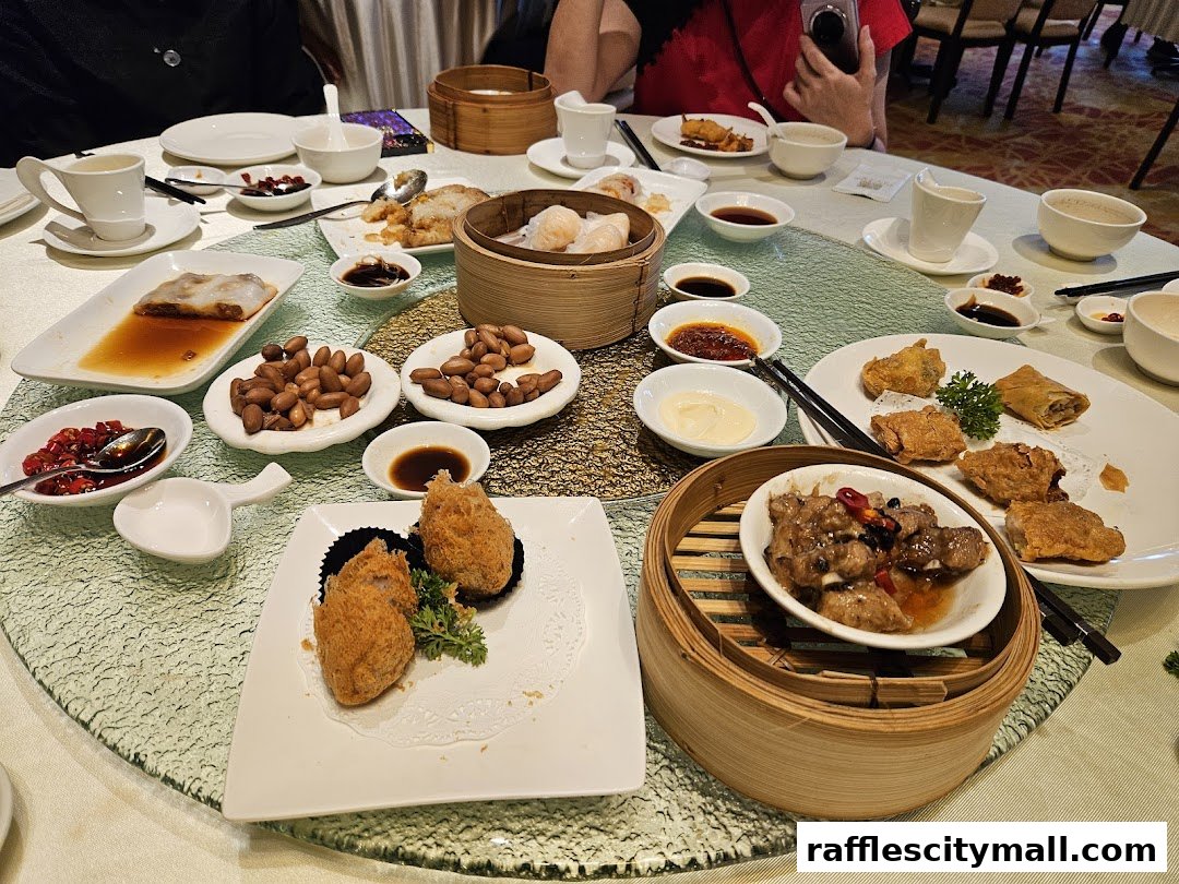 A table laden with various Asian dishes, including dim sum, fried items, and ribs.