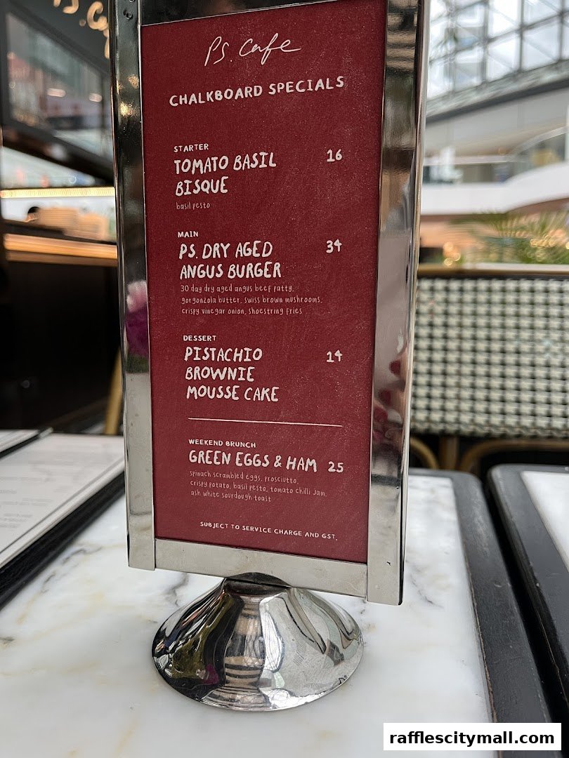 A menu board displaying PS.Cafe's chalkboard specials, including starters, mains, desserts, and weekend brunch.