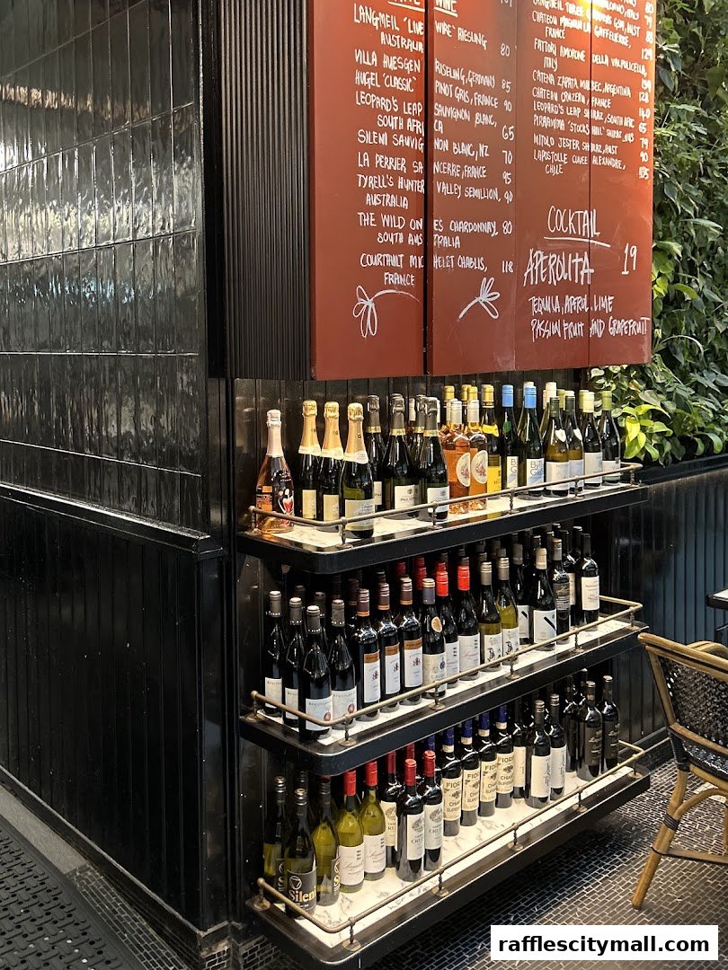 A display of wine bottles on shelves in front of a menu board with various wine selections.