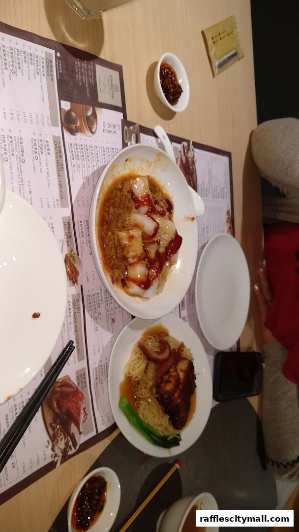 A table setting with two bowls of Chinese food, chopsticks, and a menu.