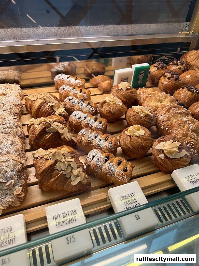 A display case filled with various freshly baked croissants and pastries.