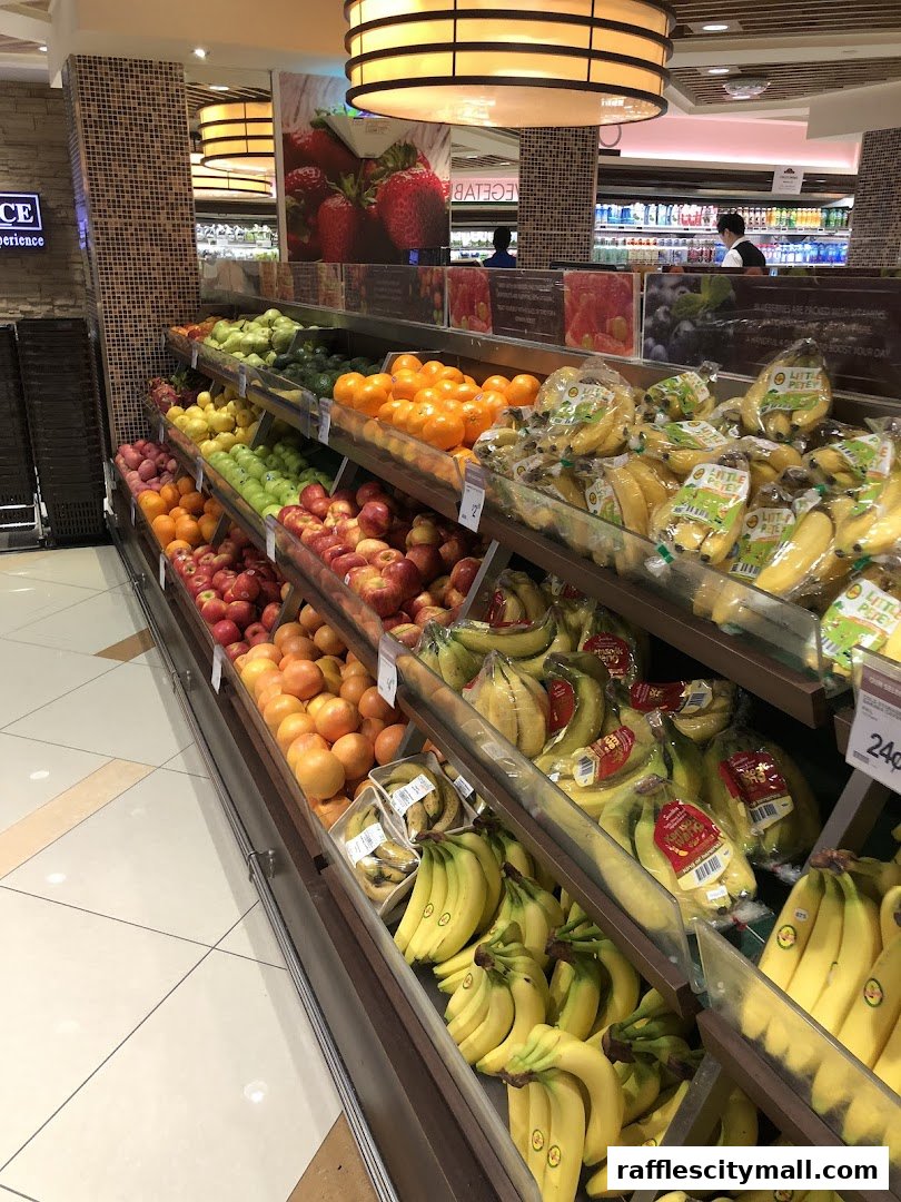 A wide selection of fresh fruits, including bananas, oranges, apples, and pears, displayed in a supermarket aisle.
