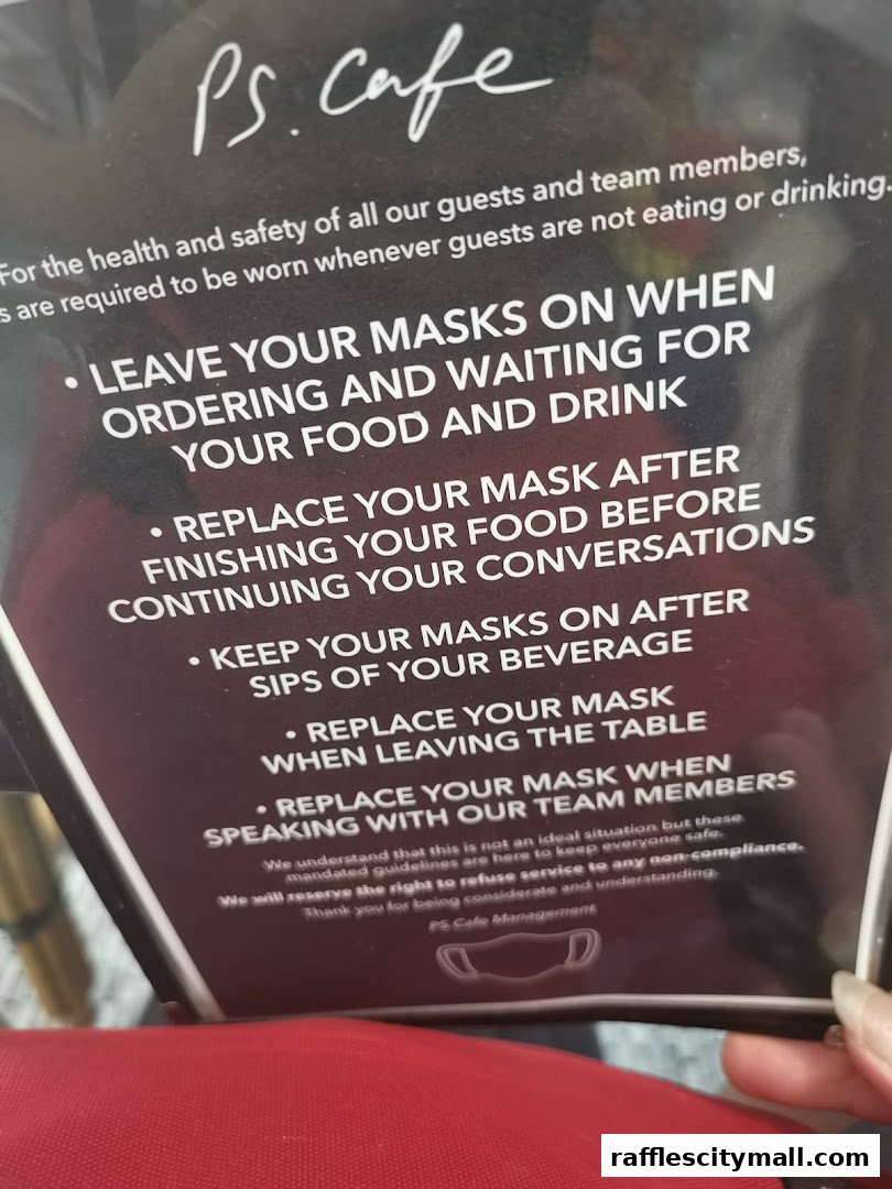 A sign from PS.Cafe detailing mask-wearing guidelines for guests.