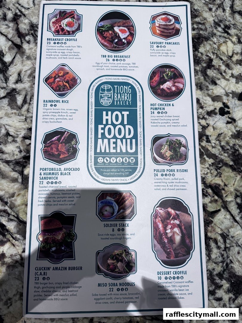 A menu from Tiong Bahru Bakery featuring hot food items with images and descriptions.
