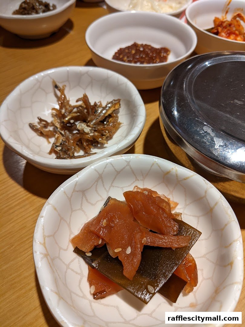 Close-up of various Korean banchan (side dishes) served in small bowls.