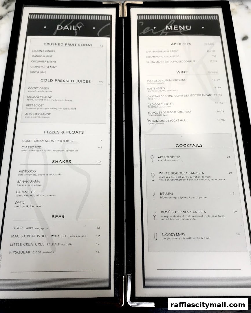A menu from PS.Cafe Raffles City, featuring drinks like crushed fruit sodas, juices, shakes, beer, aperitifs, wine, and cocktails.