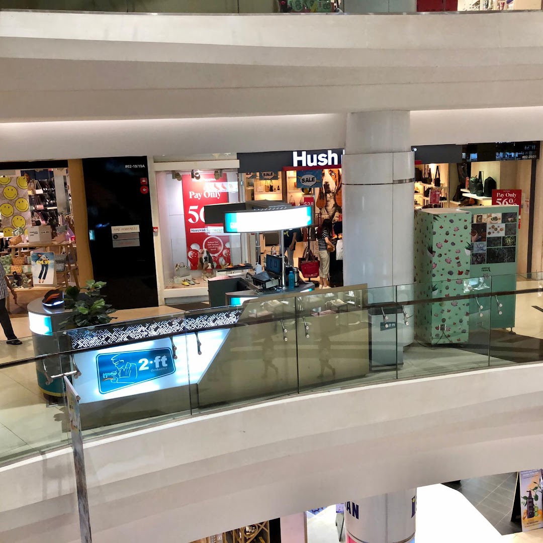 An overhead view of the 2ft Orthotics counter in a bustling shopping mall, surrounded by other retail stores.