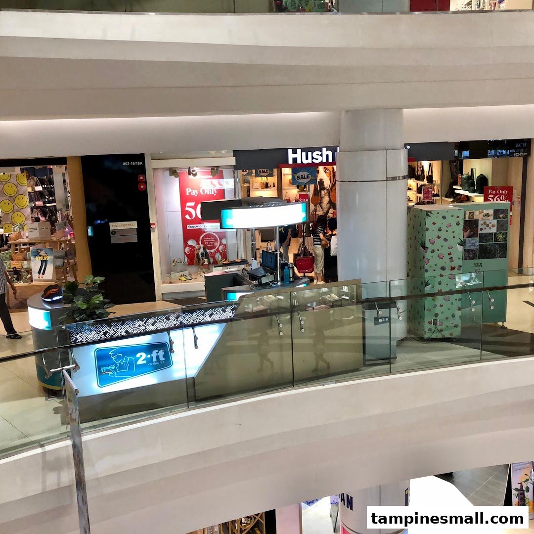 An overhead view of the 2ft Orthotics counter in a bustling shopping mall, surrounded by other retail stores.