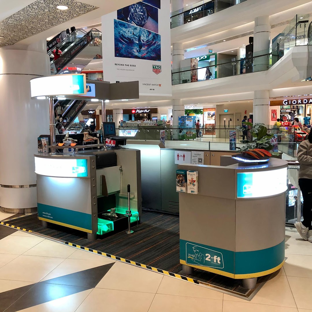 A 2ft Orthotics kiosk with a foot scanning station in a busy shopping mall.