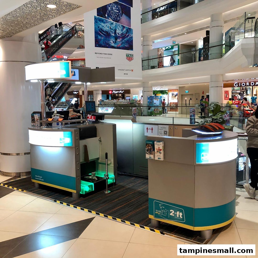 A 2ft Orthotics kiosk with a foot scanning station in a busy shopping mall.