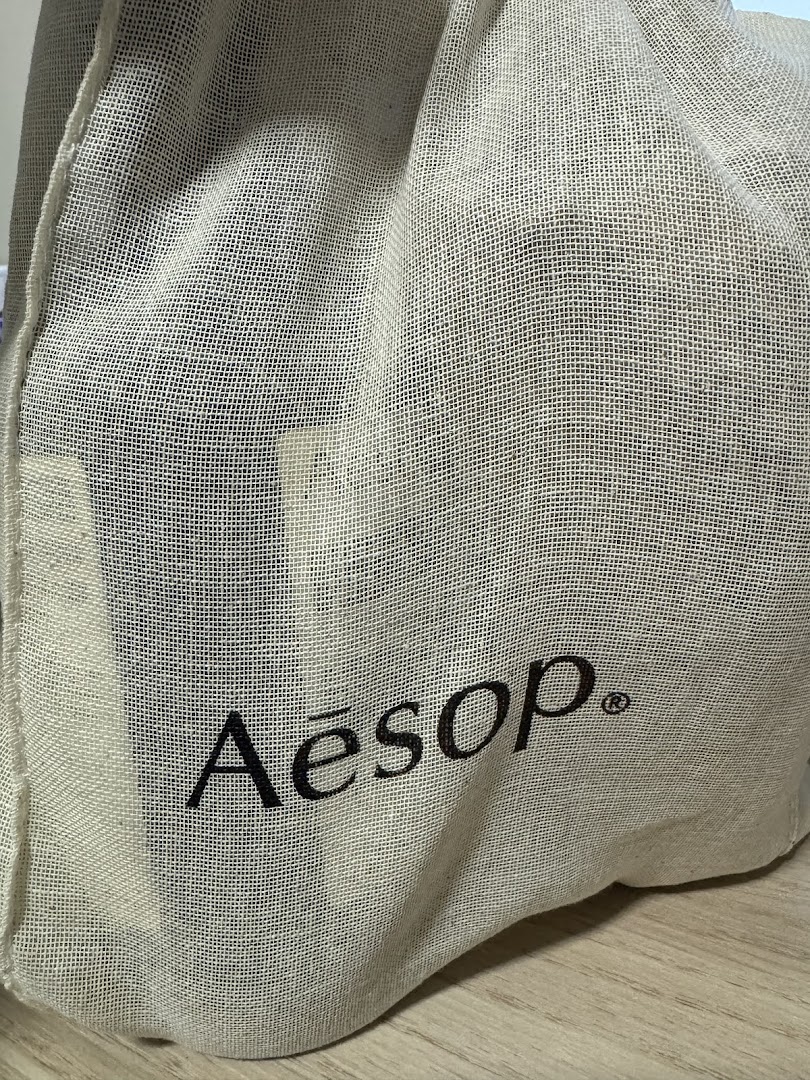Close-up of an Aesop branded reusable cloth bag, showcasing the logo.