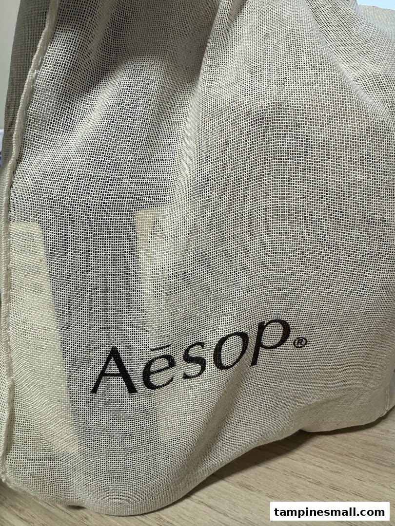 Close-up of an Aesop branded reusable cloth bag, showcasing the logo.