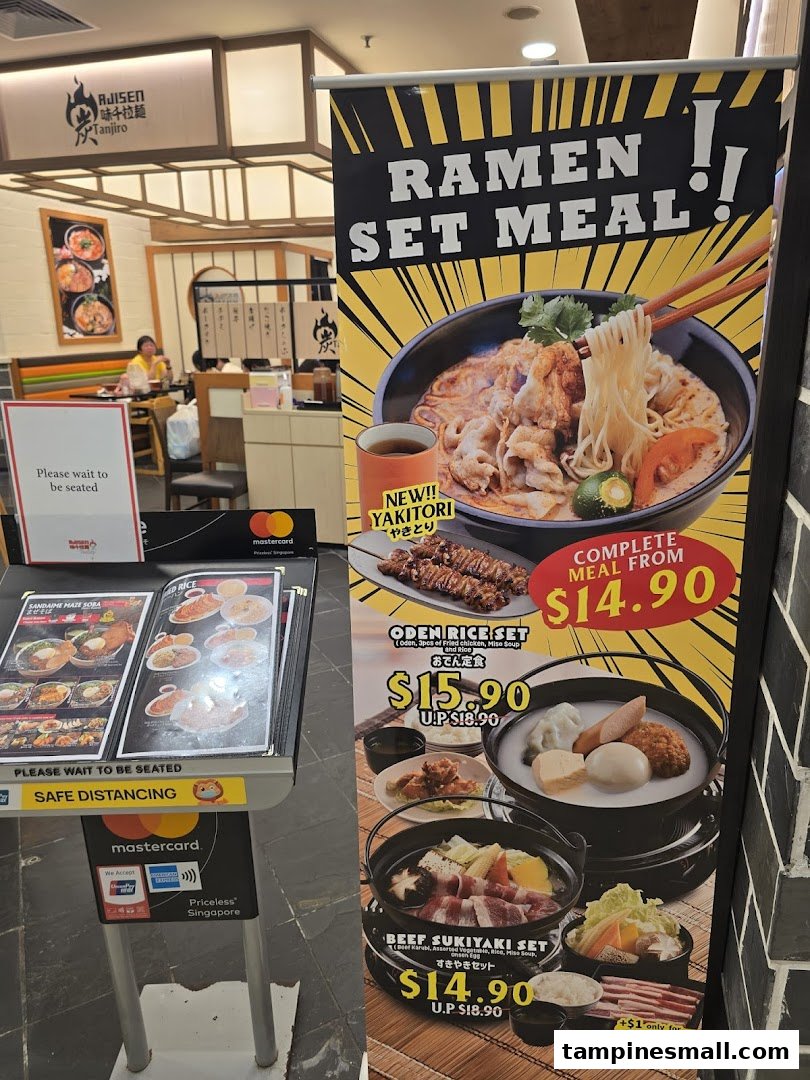 A promotional banner and stand displaying ramen and Japanese set meals with prices at Ajisen Tanjiro.
