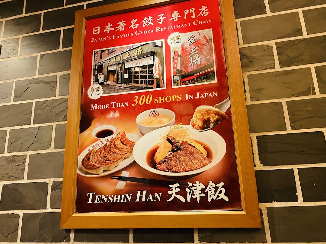 A framed promotional poster showcasing gyoza and Tenshin Han from a famous Japanese restaurant chain.