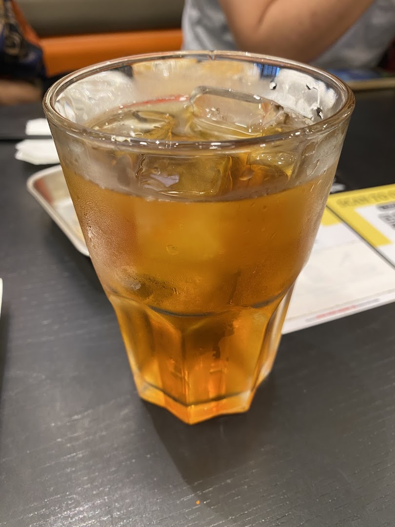 A refreshing glass of iced tea with ice cubes on a dark table.