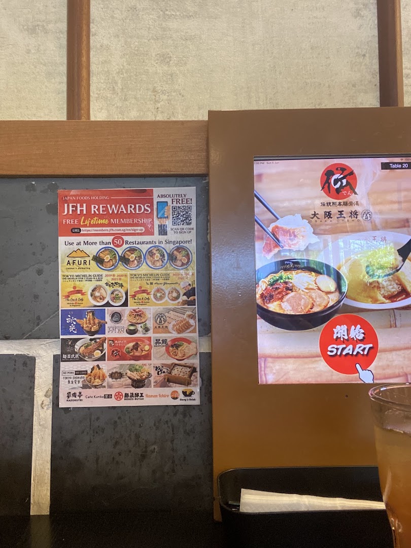 An in-store view featuring a digital ordering screen and a multi-brand loyalty program poster.