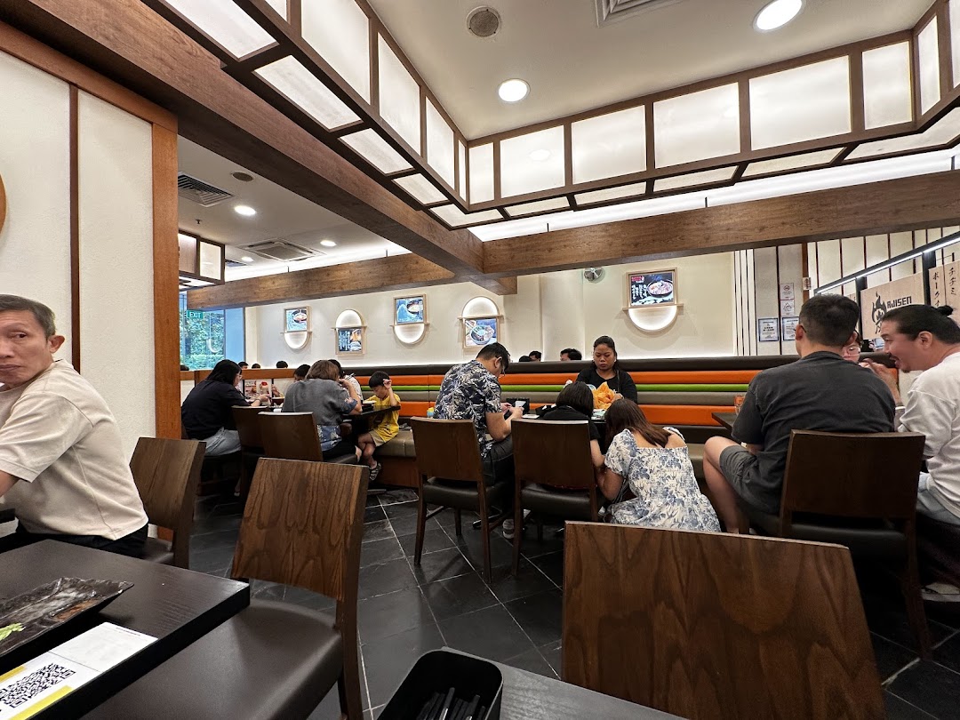 Diners enjoying meals in a brightly lit, modern Japanese-style restaurant interior.