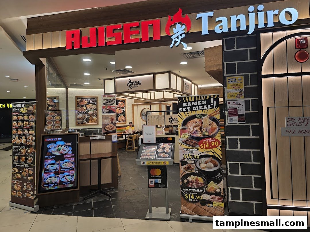 The storefront of Ajisen Tanjiro, a Japanese ramen restaurant, featuring its entrance and promotional banners.